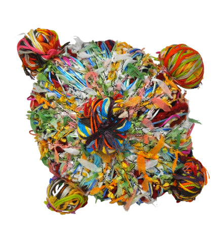 a circular sculpture made up of many different colored threads wrapped and tied together. Five small ball sculptures are tied to outer surface of the main structure. 