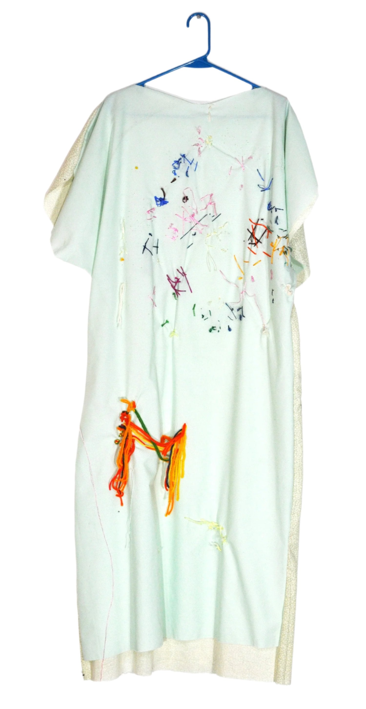 A long shift dress with short sleeves. The front of the dress is a pale seafoam green. There are multicolored embroidered stitches in abstract patterns near the bodice. Further down, there is thicker threads in vibrant shades of red, yellow, orange, and green that have been added to the garment. 