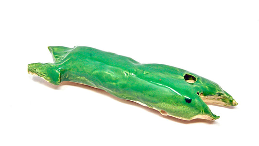 A ceramic whale with green glaze. Its mouth is opened and the eye socket is hollowed out. 