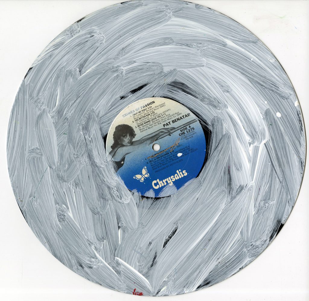 A vinyl record by Pat Benatar, Crimes of Passion, is overlaid with white acrylic paint by NIAD Studio Artist Christian Vassell.