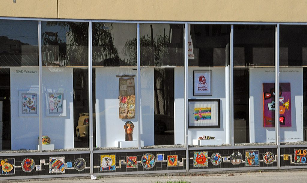 NIAD Art Centers front windows display a series of artworks by African American artists including ceramics, prints, and drawings.