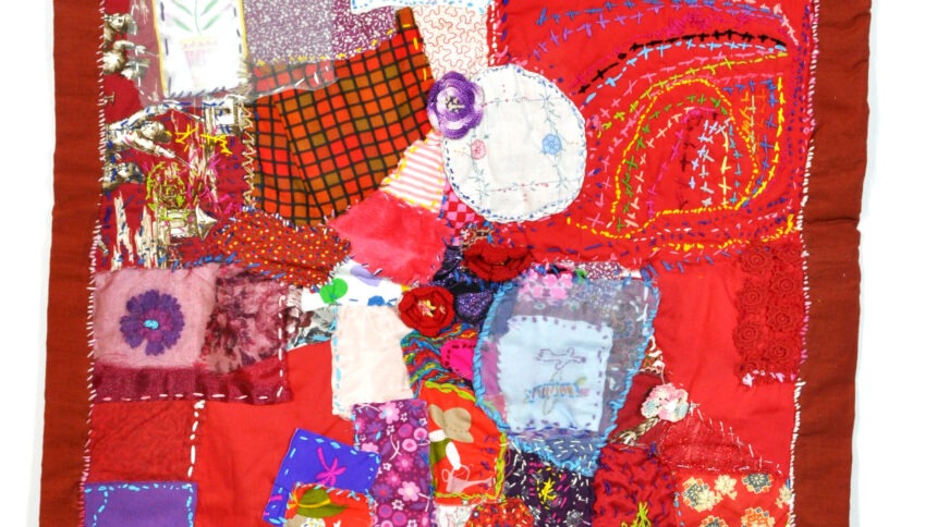a brightly colored quilt, predominantly red