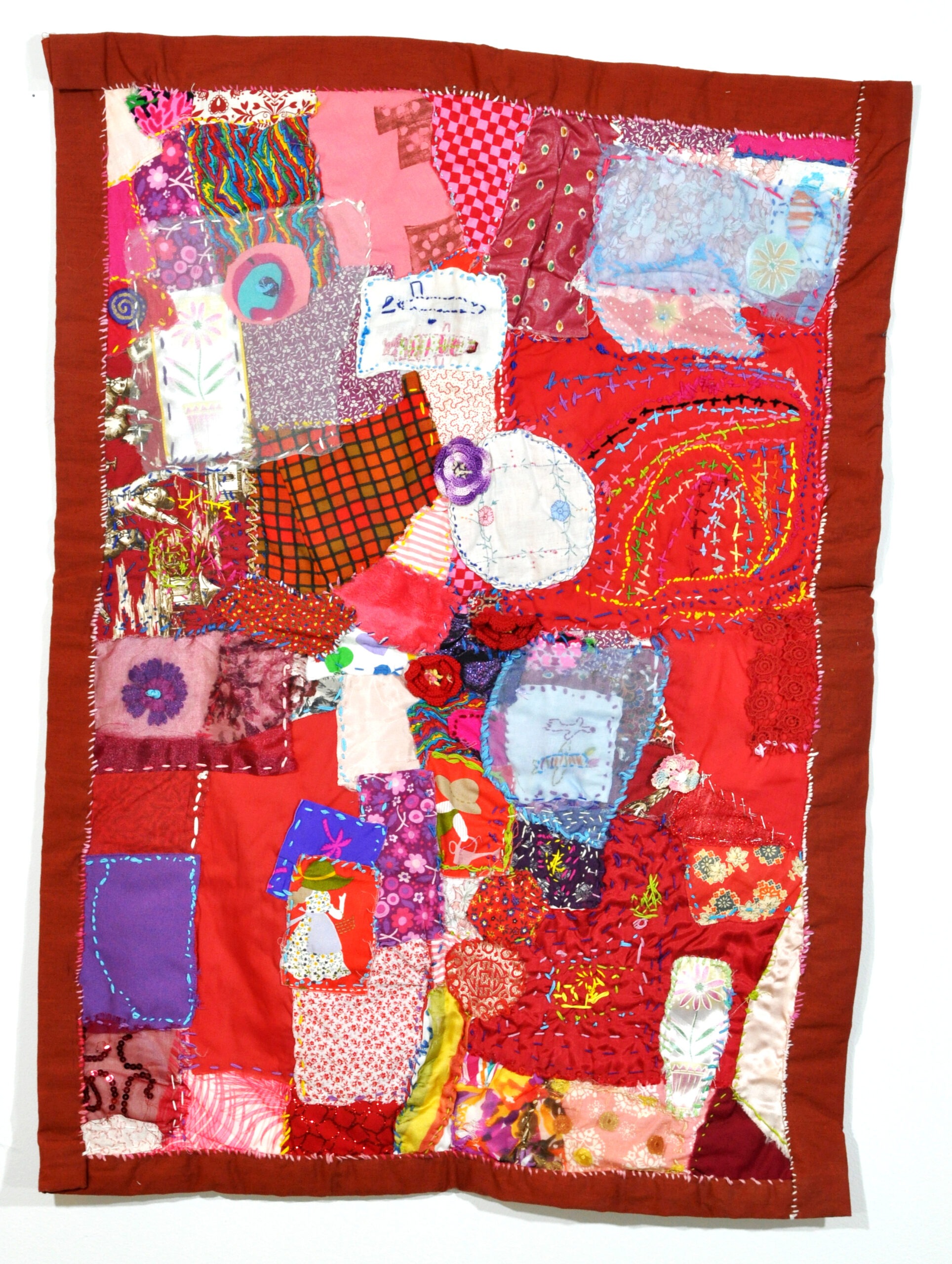 a brightly colored quilt, predominantly red