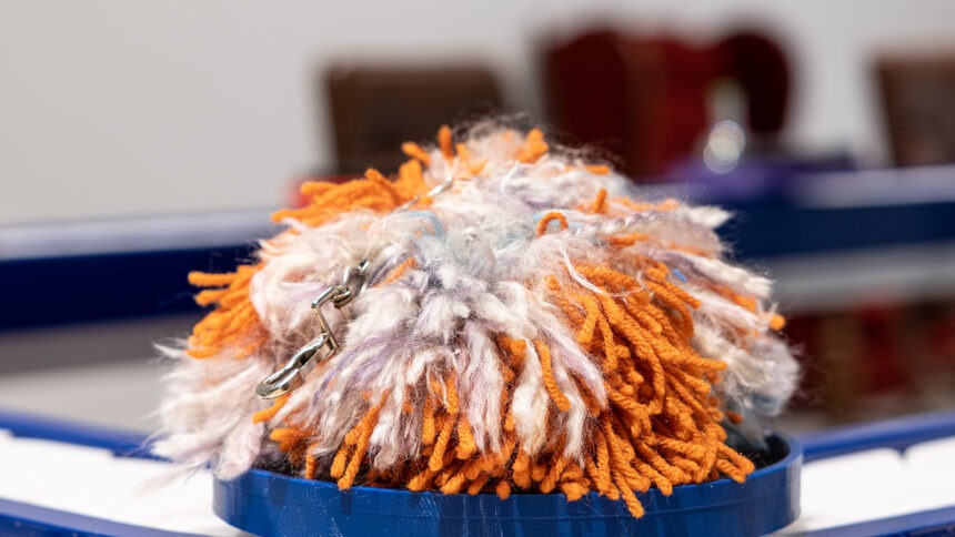 a pom pom on a conveyor belt in an art gallery setting