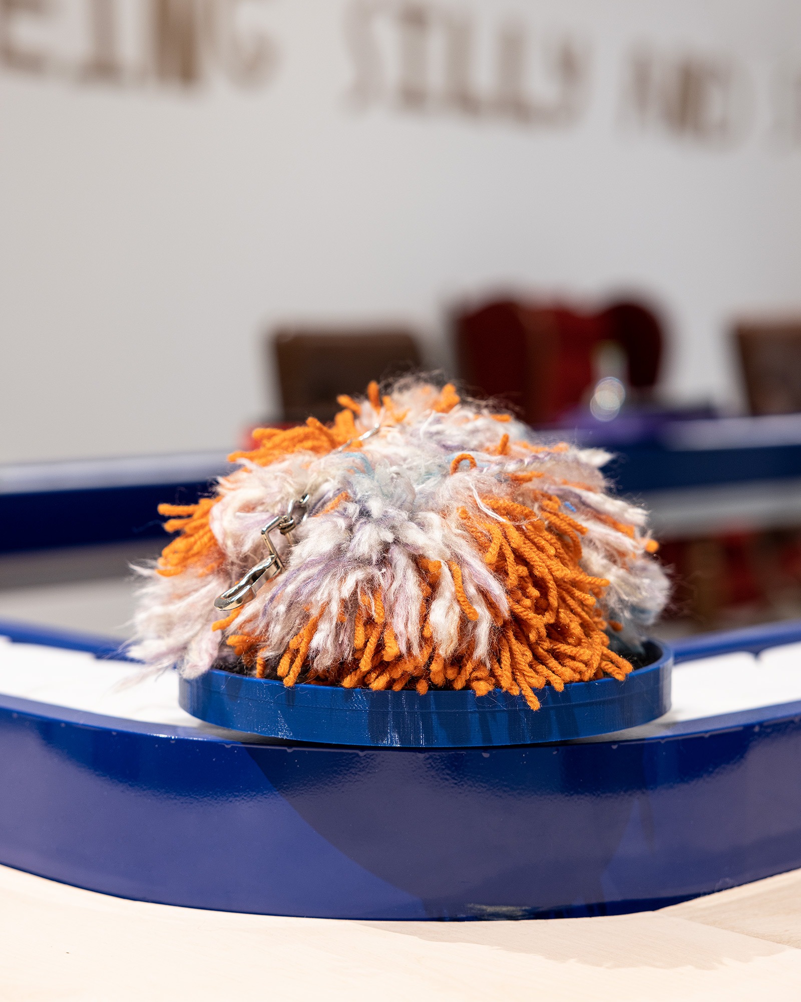 a pom pom on a conveyor belt in an art gallery setting